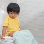 anak sembelit sedang duduk di toilet