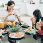 anak sedang sarapan makanan sehat bersama ayah & ibunya