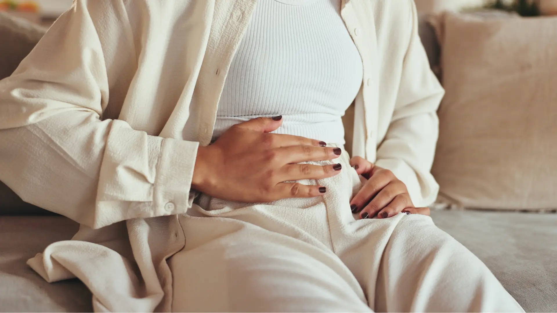 seorang wanita sedang sakit perut karena gut health yang tidak seimbang