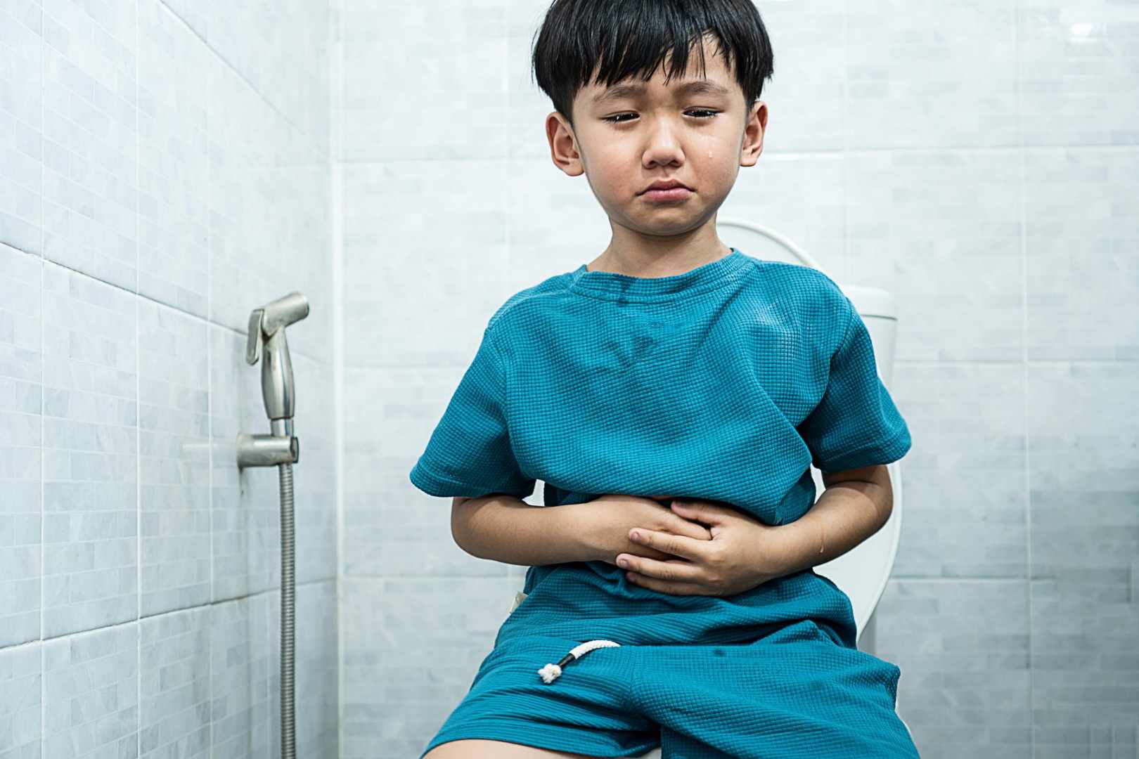 seorang anak sedang duduk di toilet karena sembelit